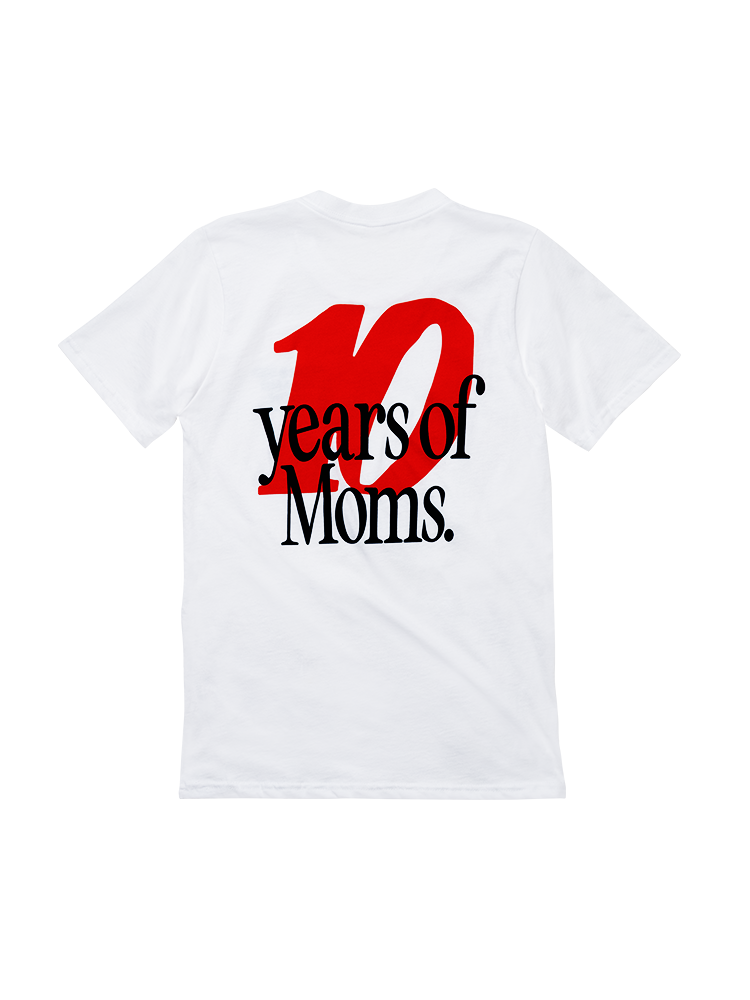 Back view of a white short sleeve tee shirt. A large red "10" is printed with overlapping black text on top that reads "years of Moms."