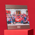 Front view of 5 x 7 inch picture frame with a photo of Moms volunteers in front of a state house, with brushed aluminum framing on top and bottom, and a white Moms Demand Action logo centered on bottom.