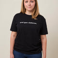 Front view of woman wearing a black unisex short sleeve t-shirt that reads end gun violence. in lowercase bold, white print.